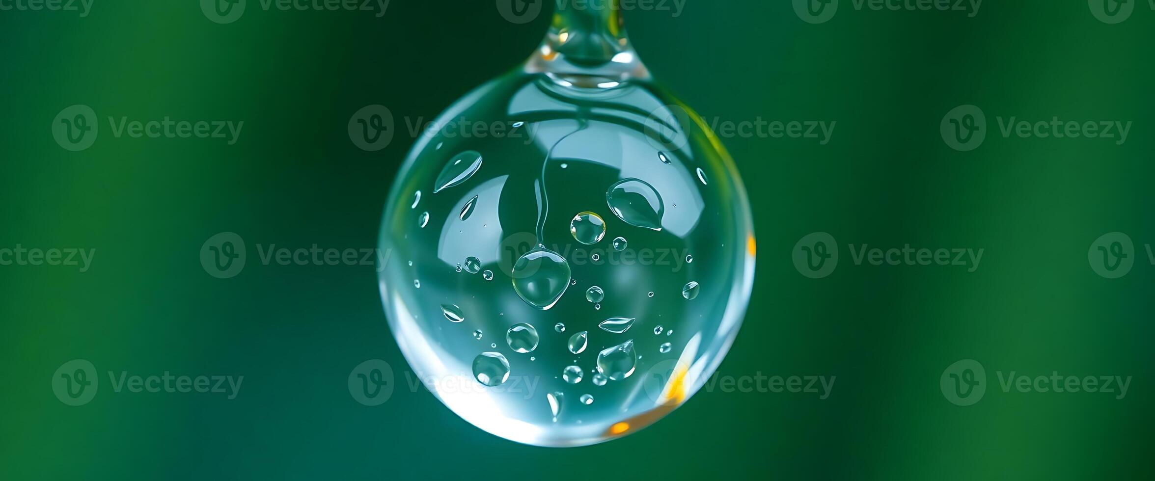drop of water hanging from a green background photo
