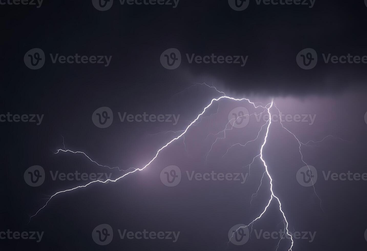 Lightning strikes over a dark sky with a cloud in the background photo