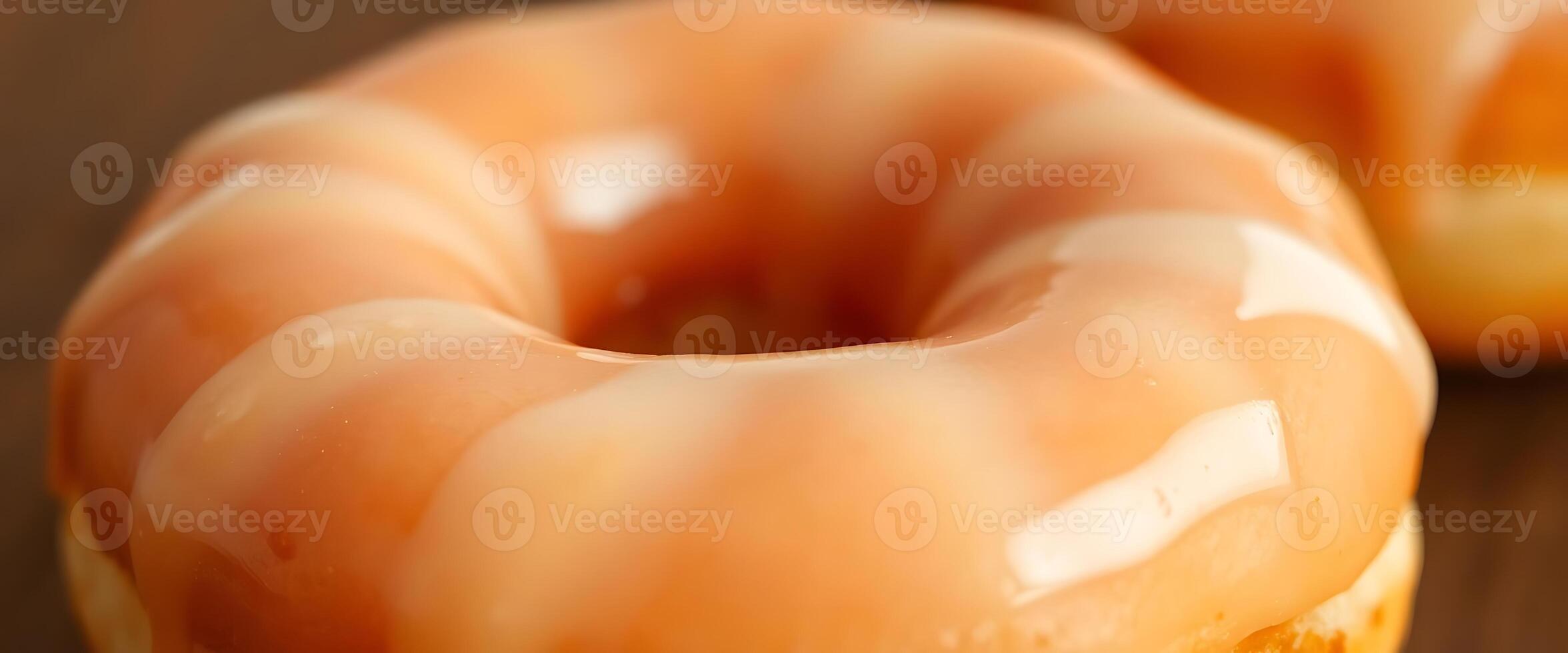 Three donuts with orange glaze sitting on a table photo