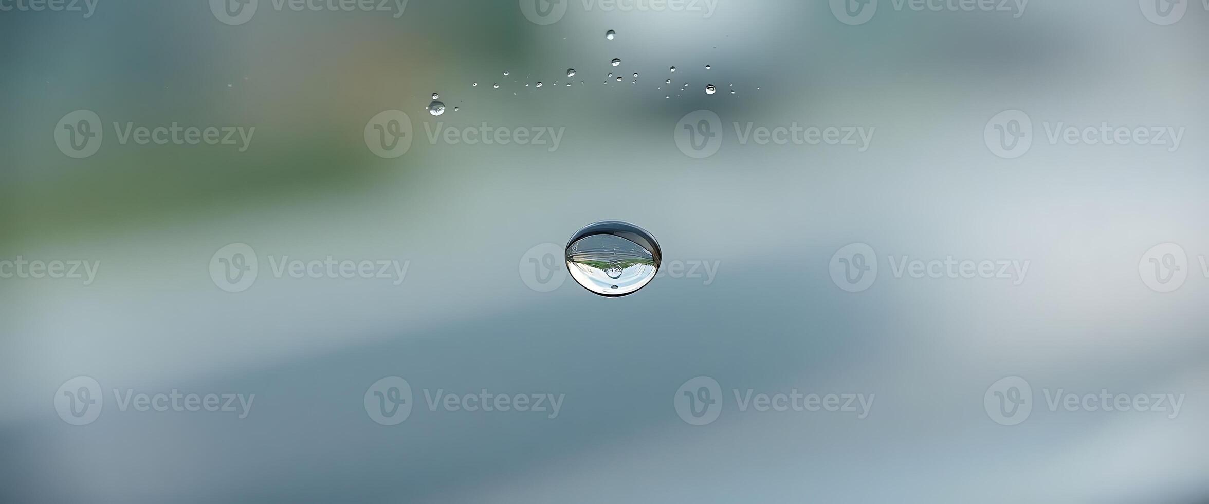 A drop of water on a window with a blurred background photo