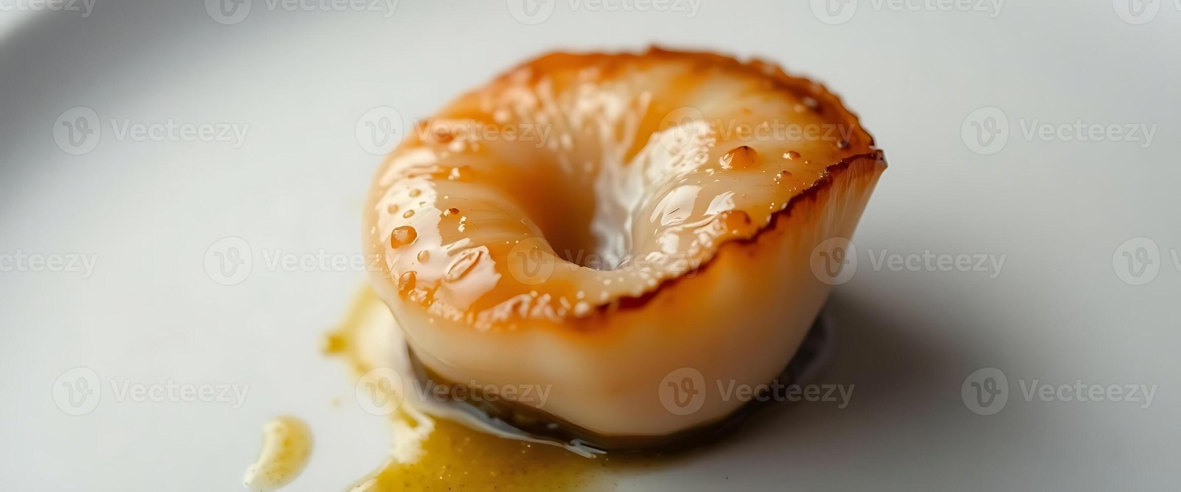 A scallop on a white plate with sauce photo