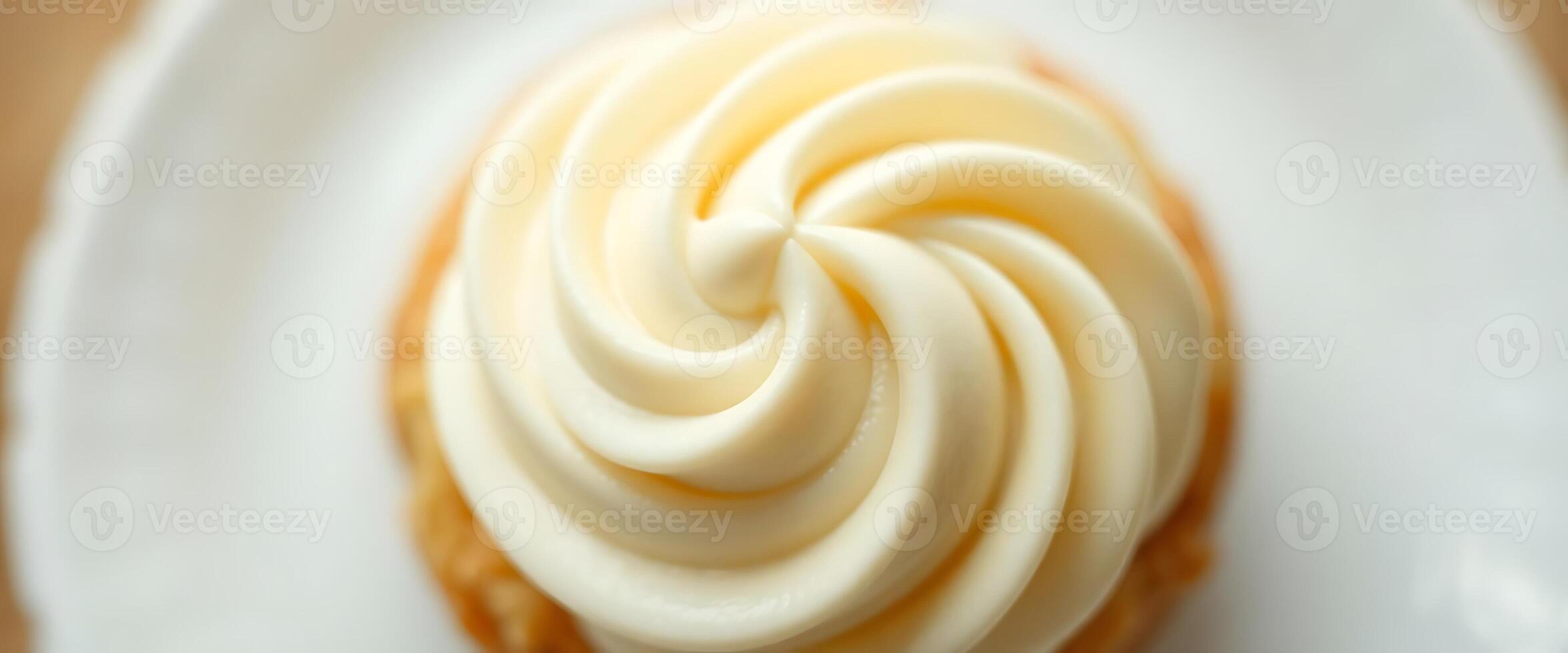 A pastry on a white plate with a swirl of frosting photo