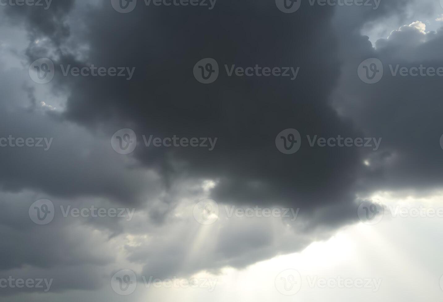 plane flying through a cloudy sky with sunbeams photo
