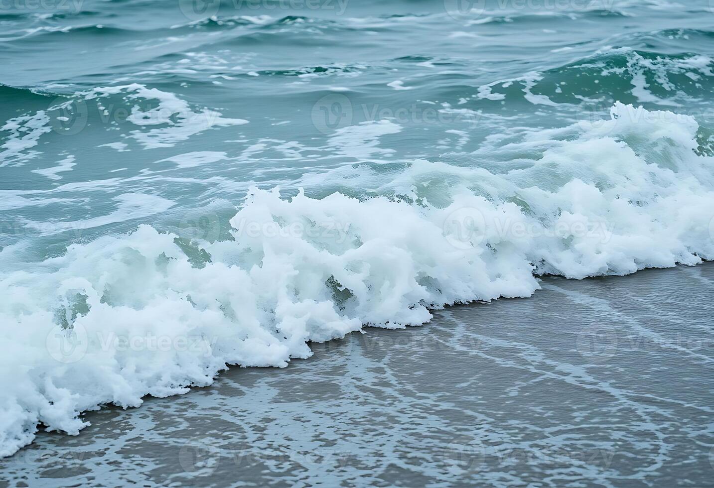 wave rolls in to the shore of a beach photo