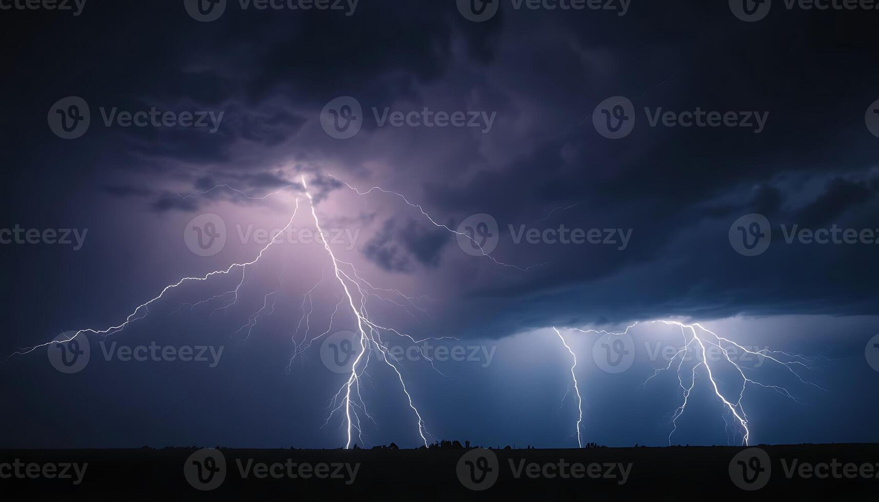 Lightning strikes over a field in the dark sky photo