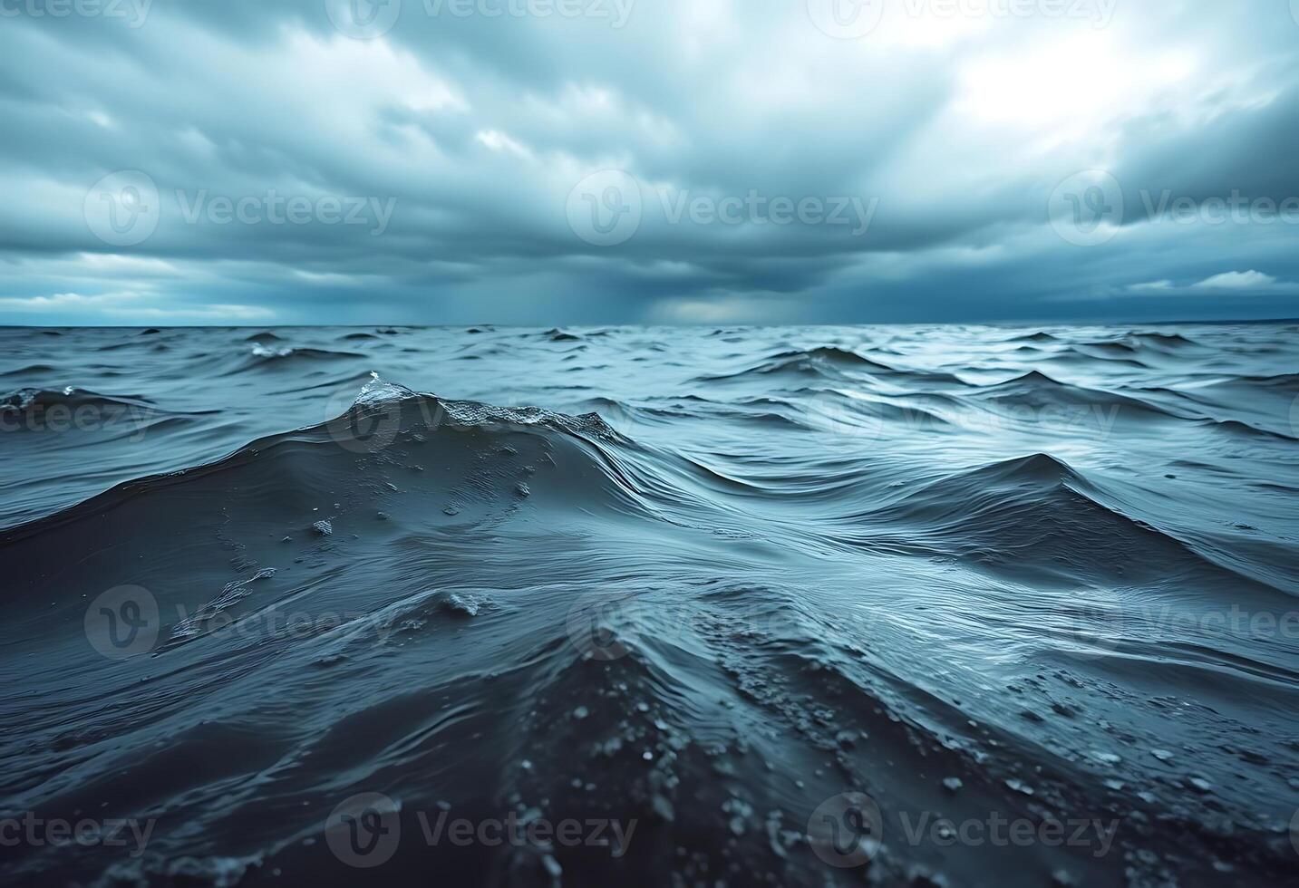 A dark ocean with waves and clouds photo