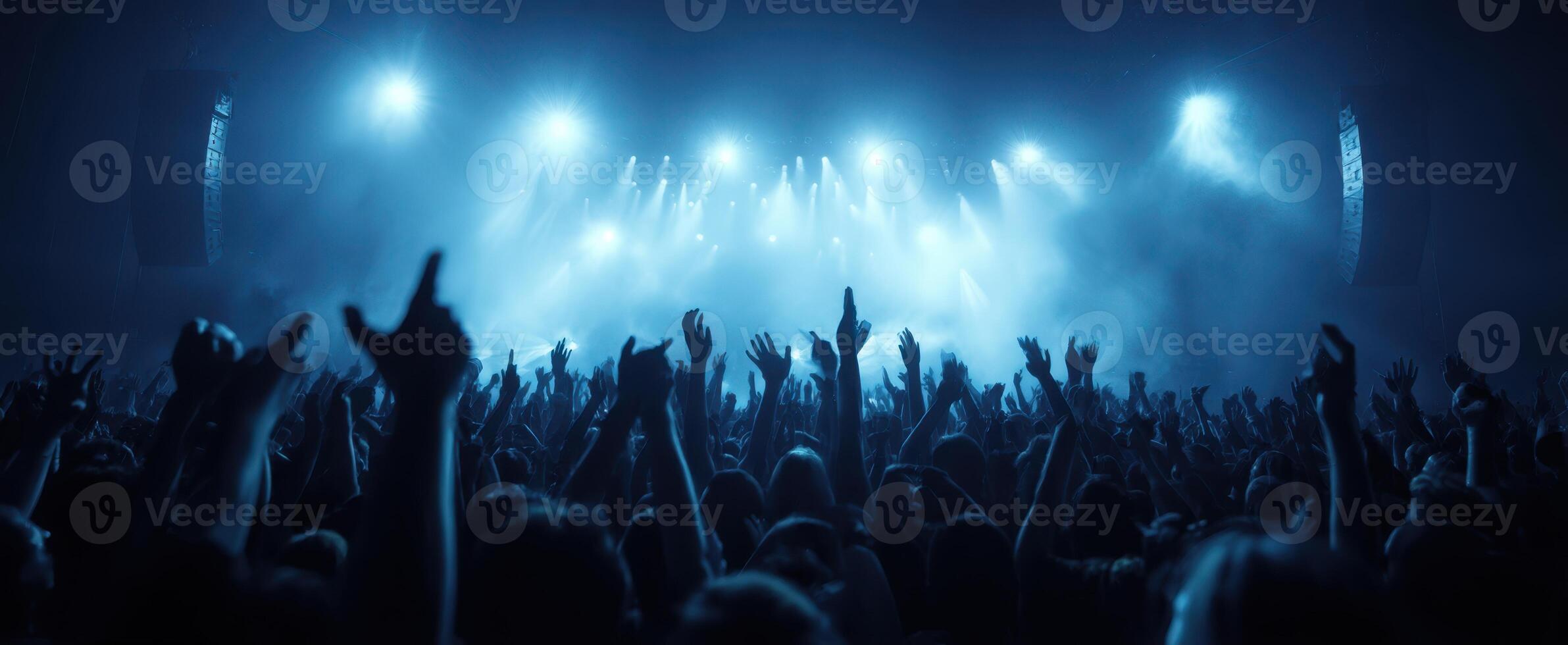 The energetic crowd raising hands at a vibrant concert performance. photo