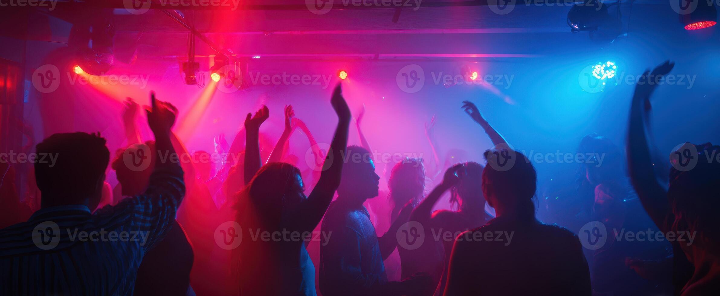 The Vibrant Atmosphere of a Nightclub Filled with Dancing People photo