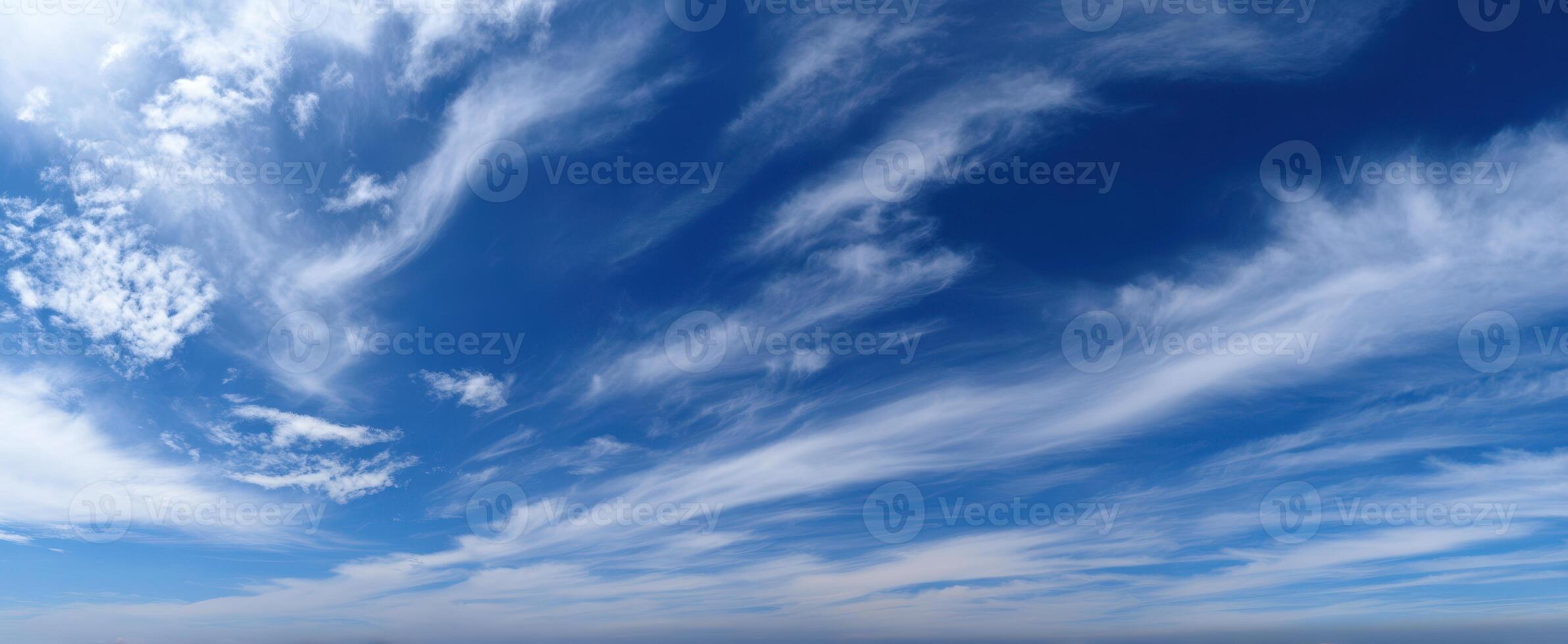 The serene sky filled with wispy clouds on a bright blue day. photo