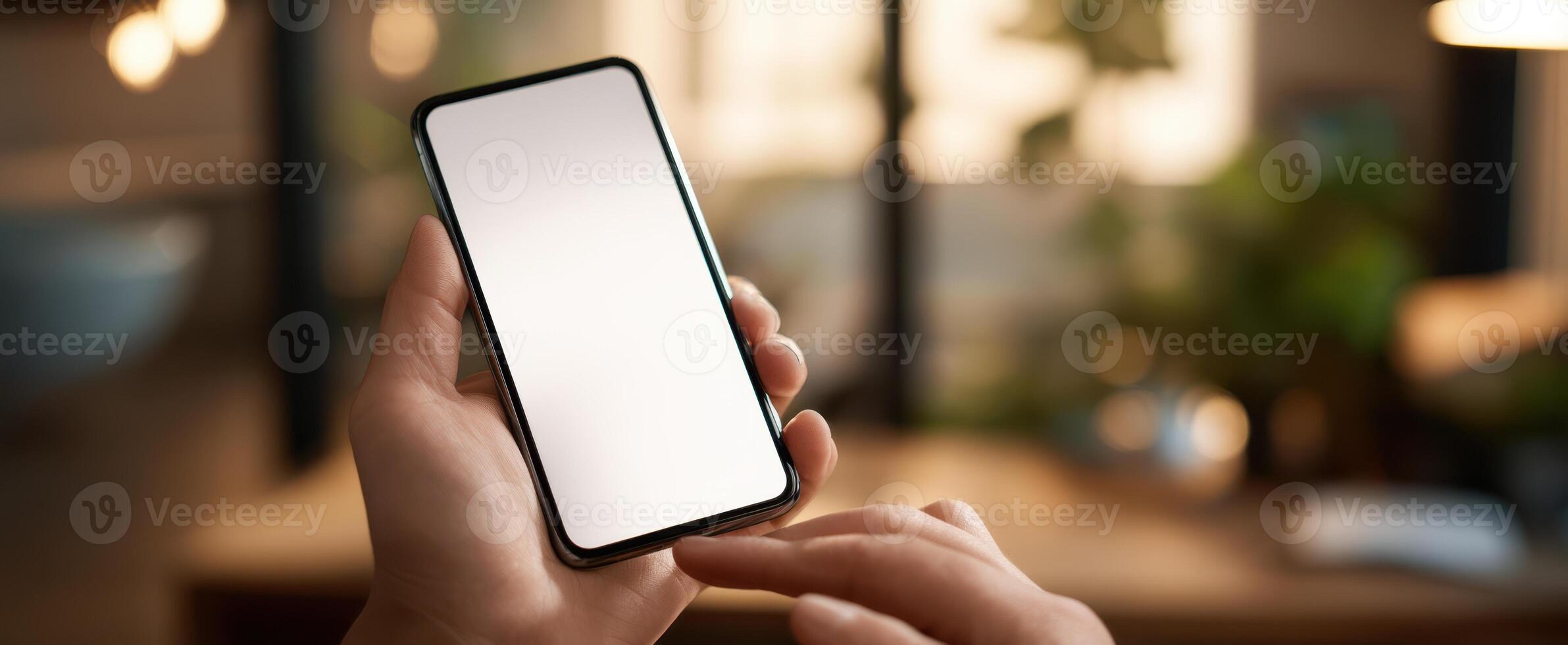 The smartphone held in hand ready for interaction in a modern workspace. photo