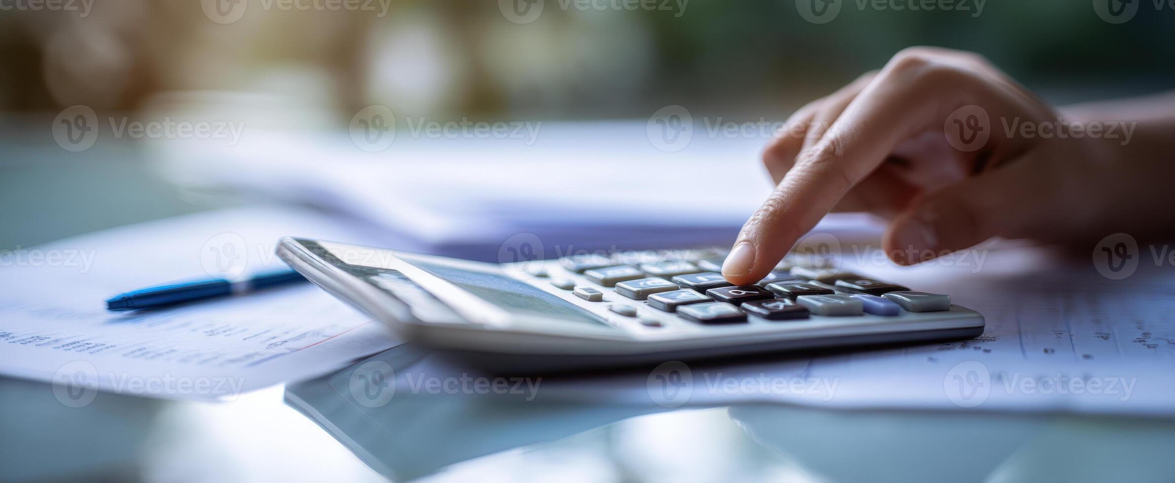 The calculator in use on a desk surrounded by financial documentation. photo