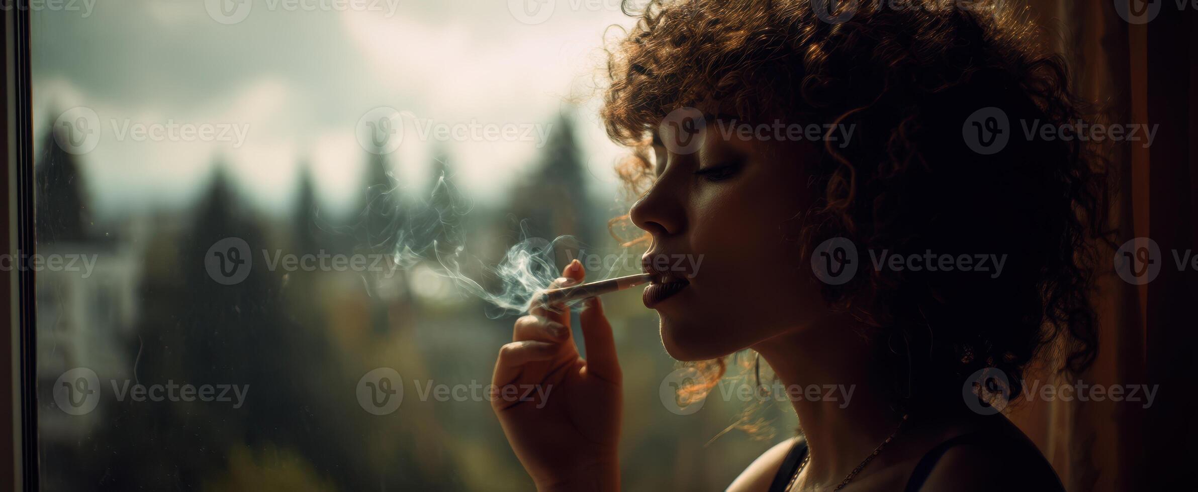 The woman enjoying a moment of solitude while smoking by the window. photo
