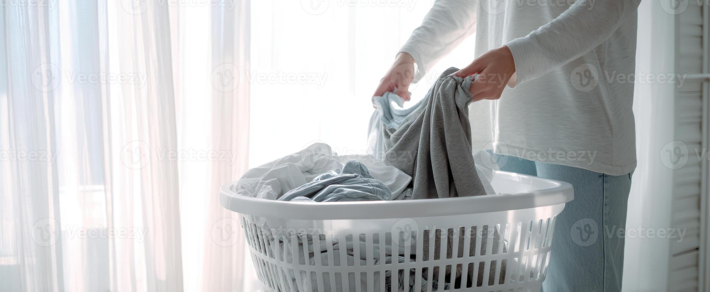 The woman organizing laundry in a bright, sunlit room near a window. photo