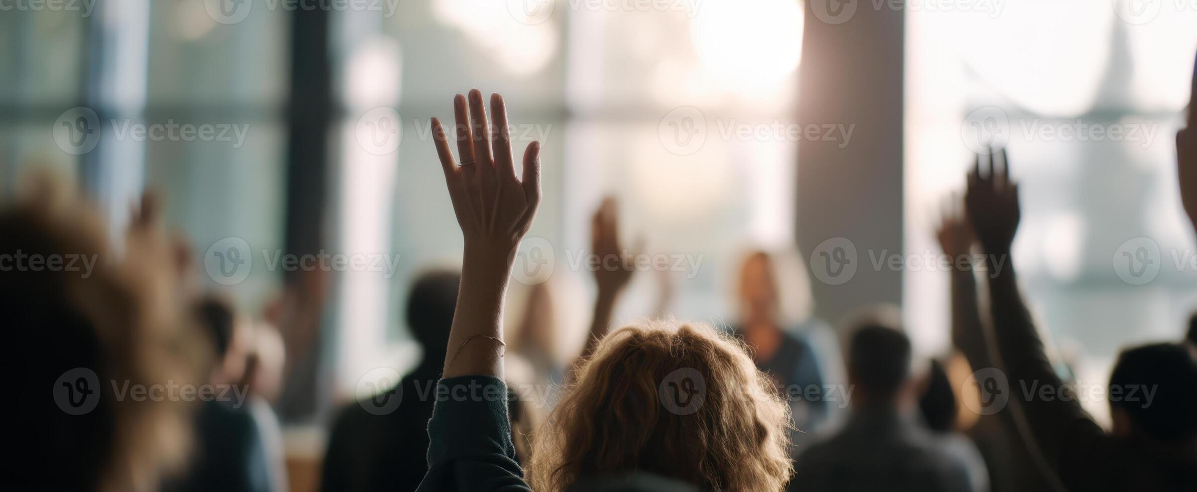 The audience actively engaging in a dynamic seminar with raised hands. photo