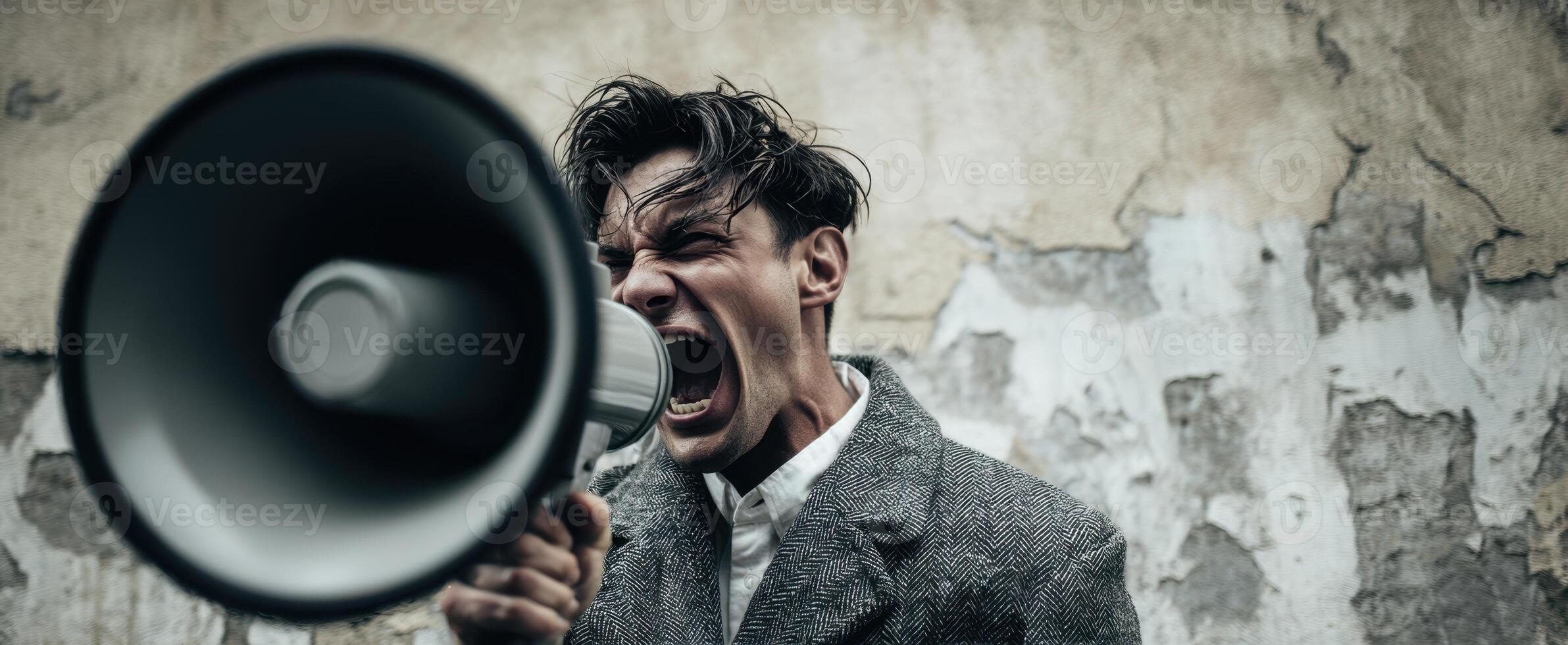 The man passionately shouting into a megaphone against a distressed backdrop. photo