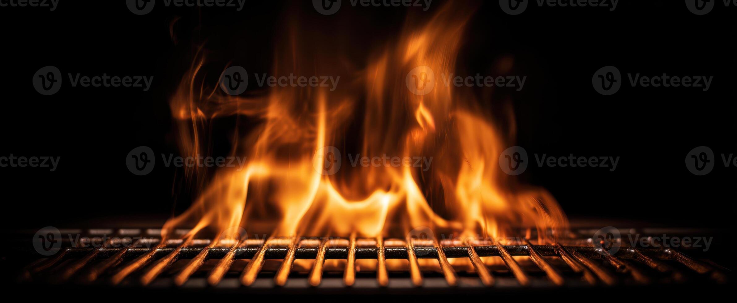 The mesmerizing flames dancing over a grill in a dark setting. photo
