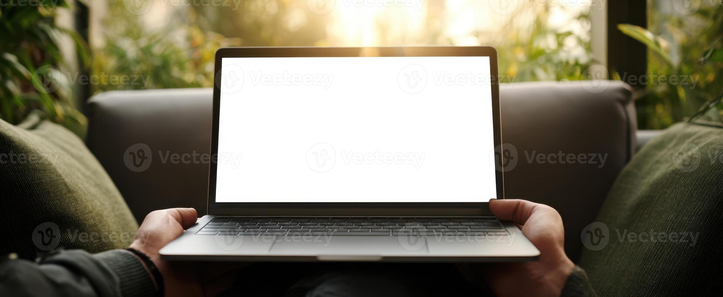 The laptop displaying a blank screen in a cozy home setting. photo