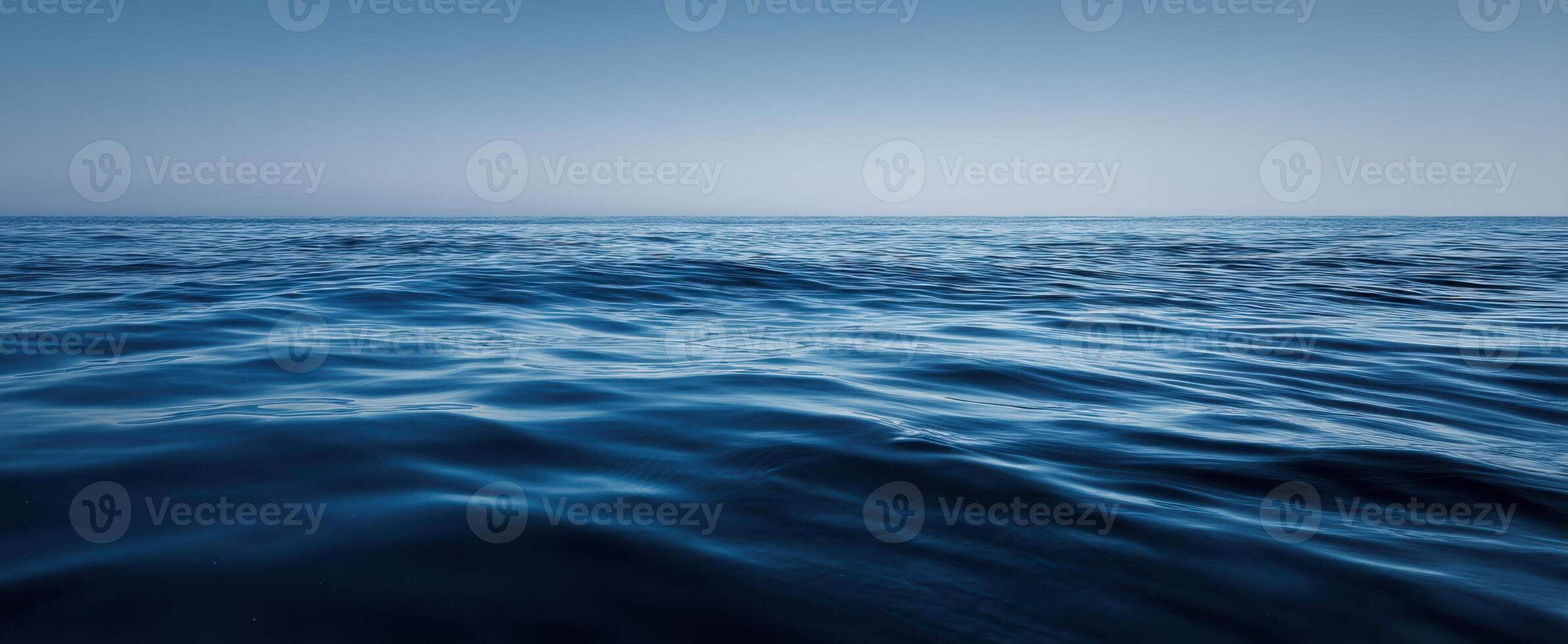 The Tranquil Surface of the Deep Blue Ocean Under a Clear Sky photo