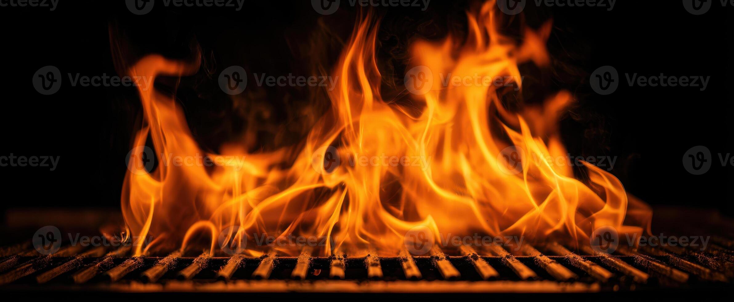The mesmerizing dance of flames over a grill in a dark setting. photo