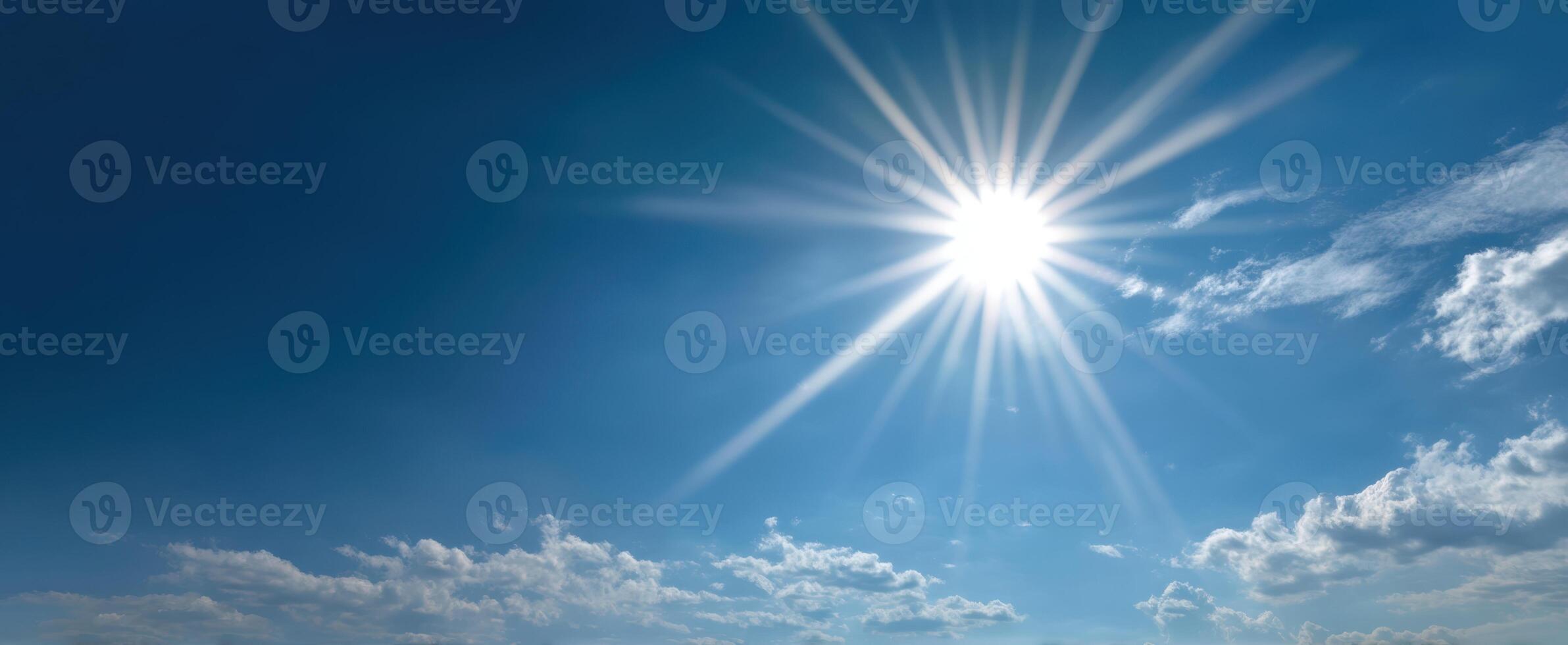 The Bright Sun Shining Over a Clear Blue Sky with Soft Clouds photo