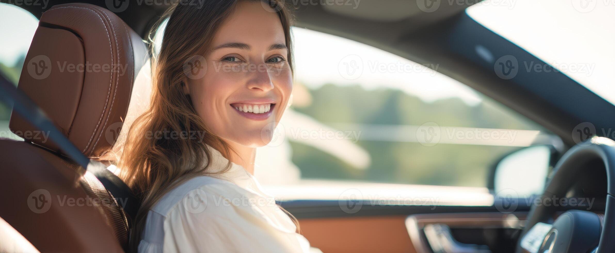 The smiling woman in a car enjoying a beautiful day outdoors photo