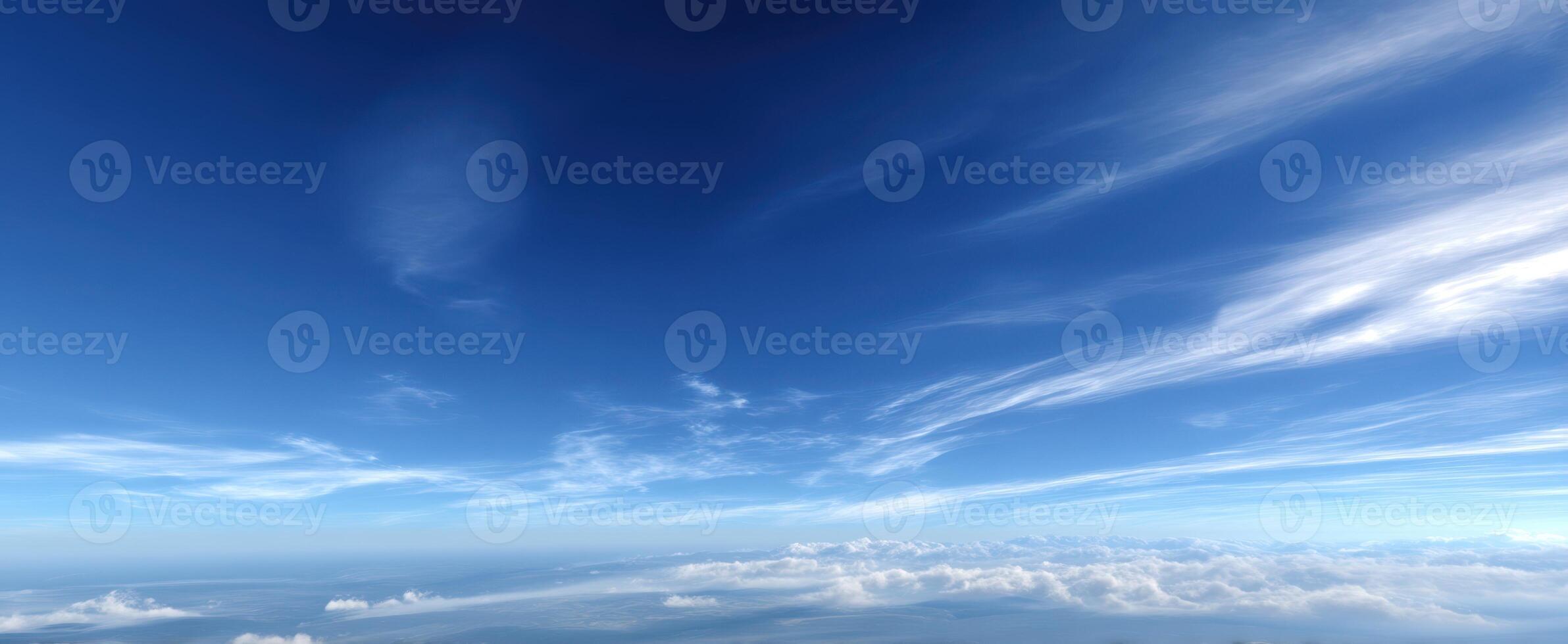 The breathtaking view of a clear blue sky with soft, wispy clouds. photo
