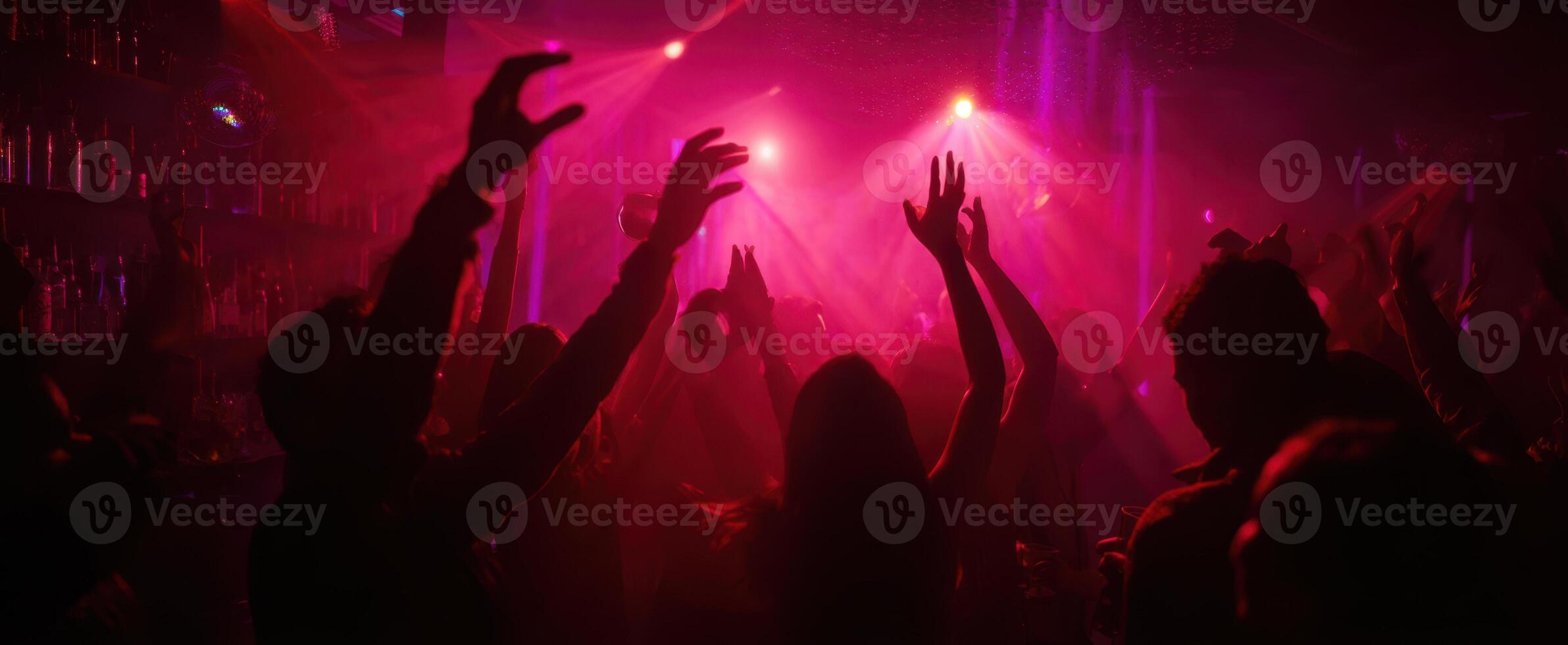 The vibrant dance party atmosphere with raised hands and colorful lights. photo