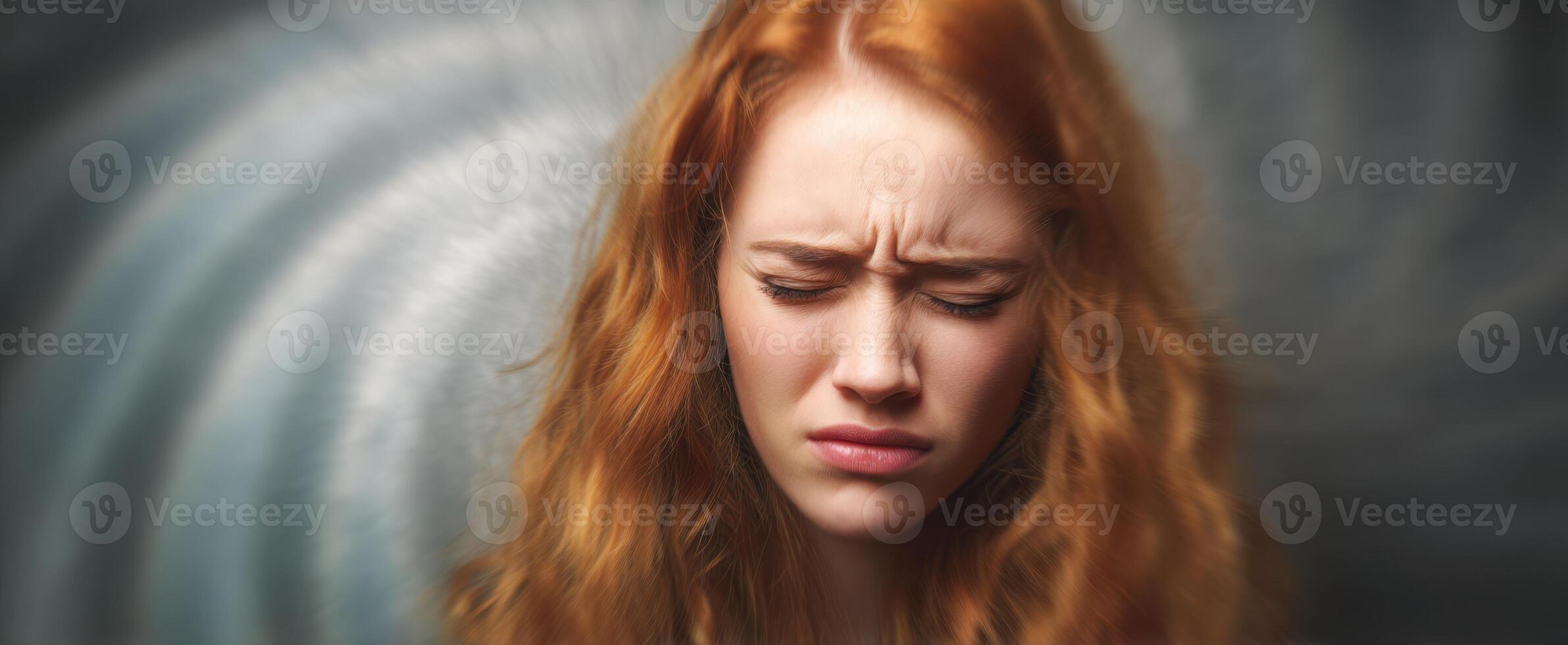 The girl with red hair expressing deep emotional turmoil in a blurred background. photo