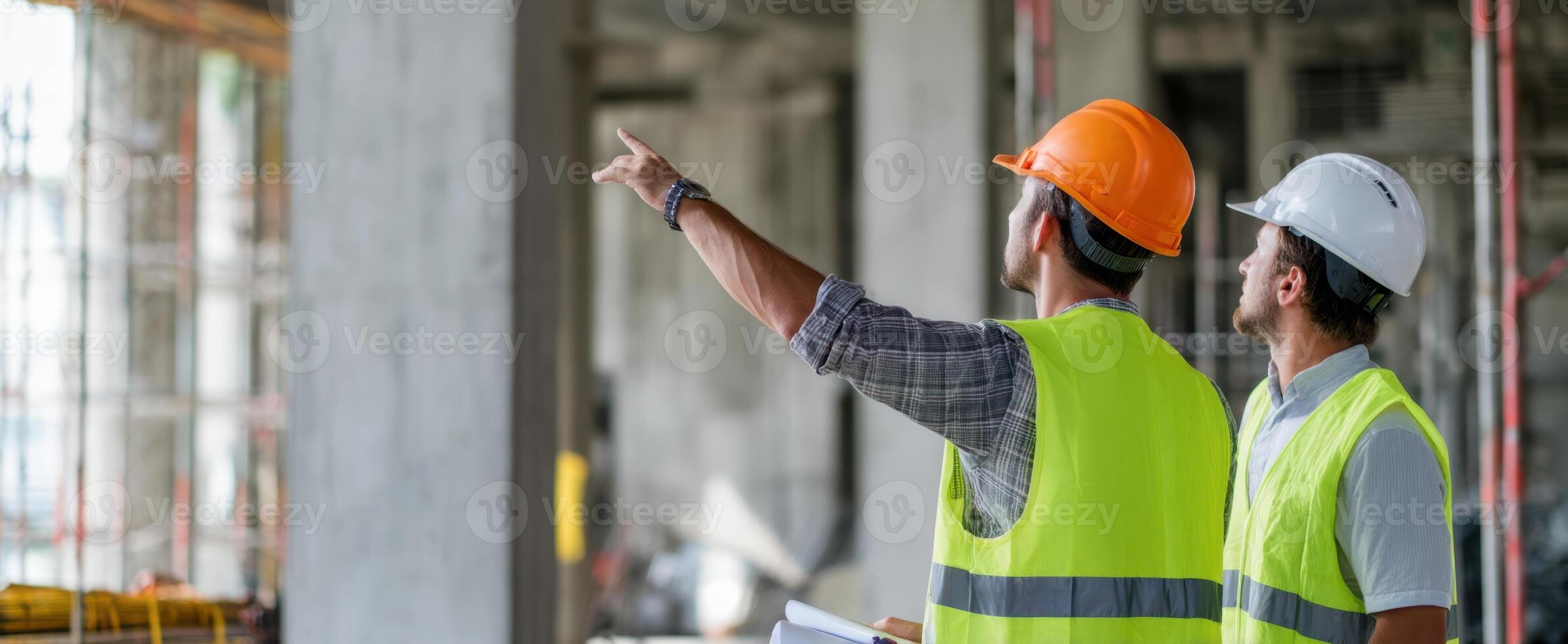 The construction workers reviewing project plans and discussing site developments. photo
