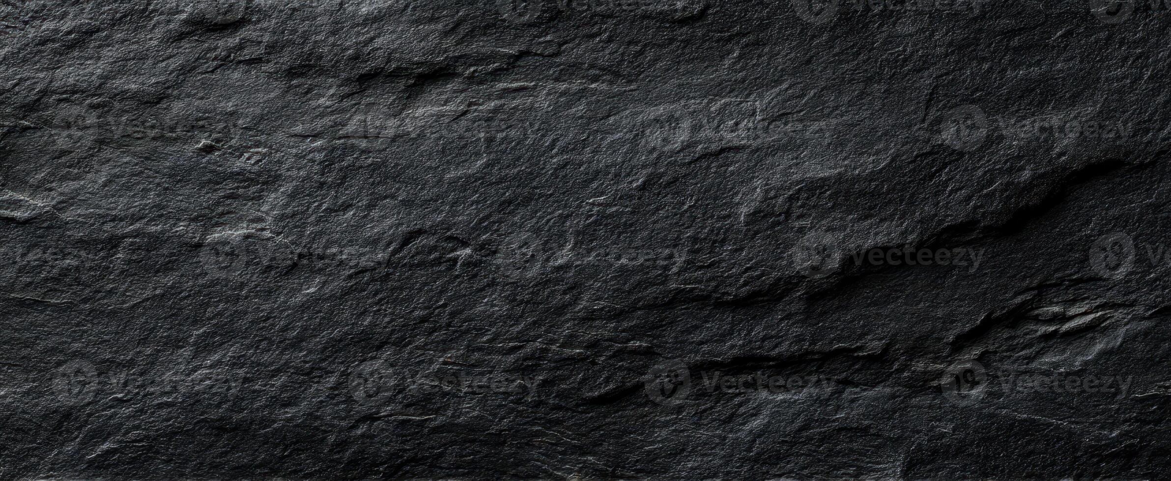 The textured surface of dark slate rock enhancing any natural backdrop. photo