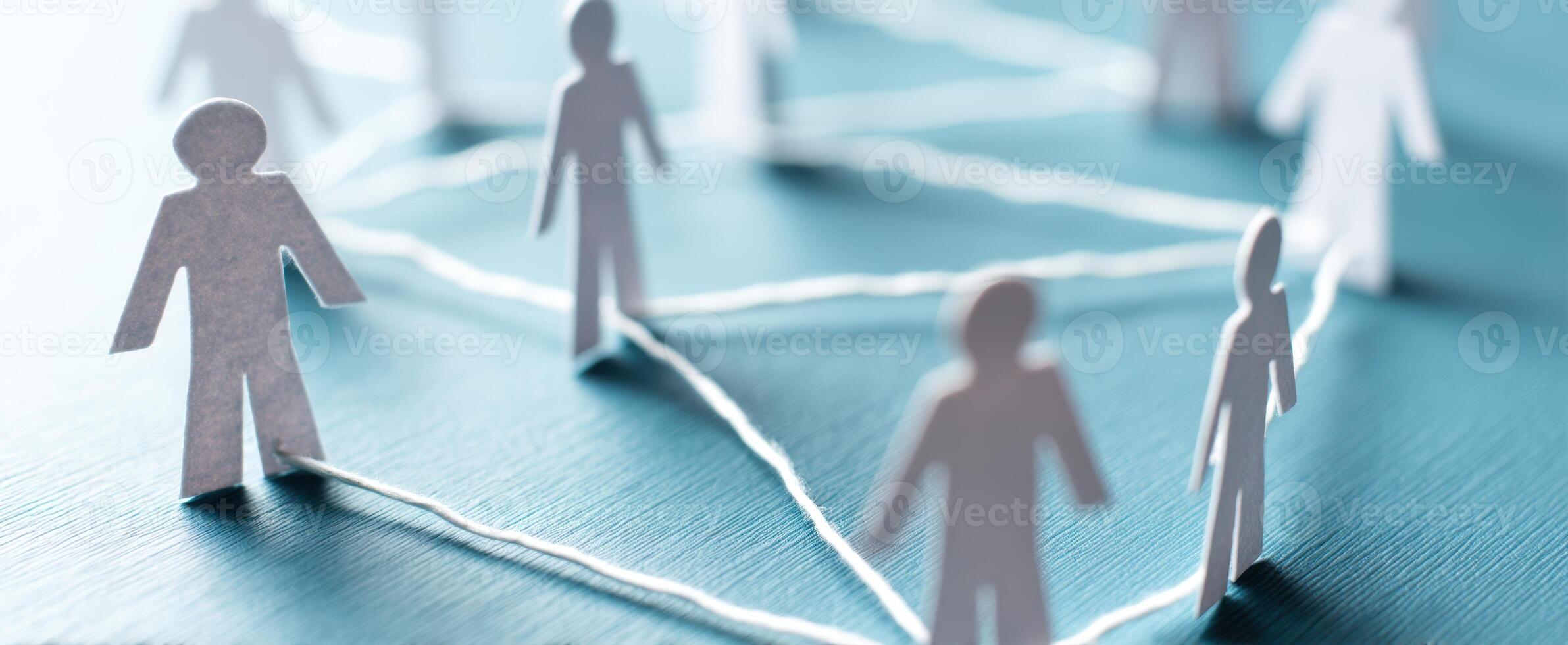 The interconnected paper figures representing teamwork and collaboration in a modern setting. photo