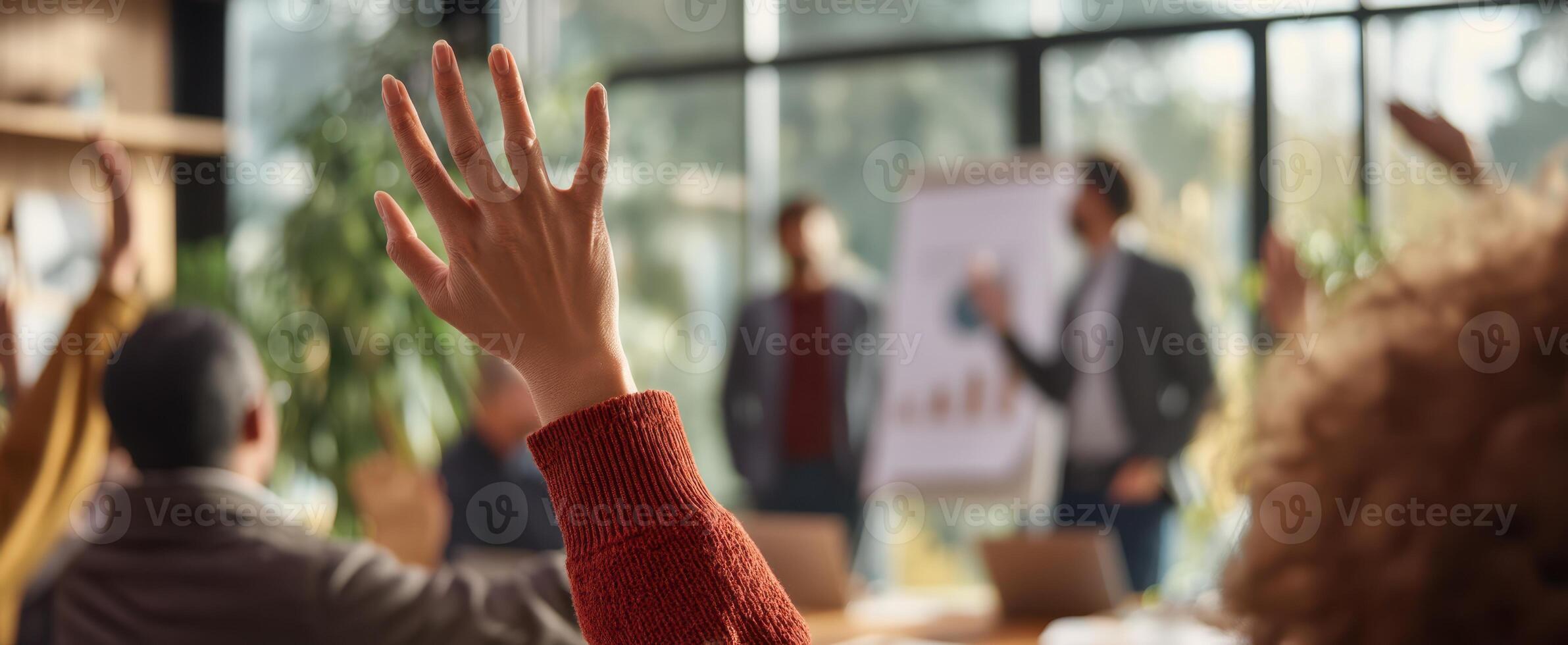 The raised hand signals engagement in a dynamic business meeting or workshop setting. photo