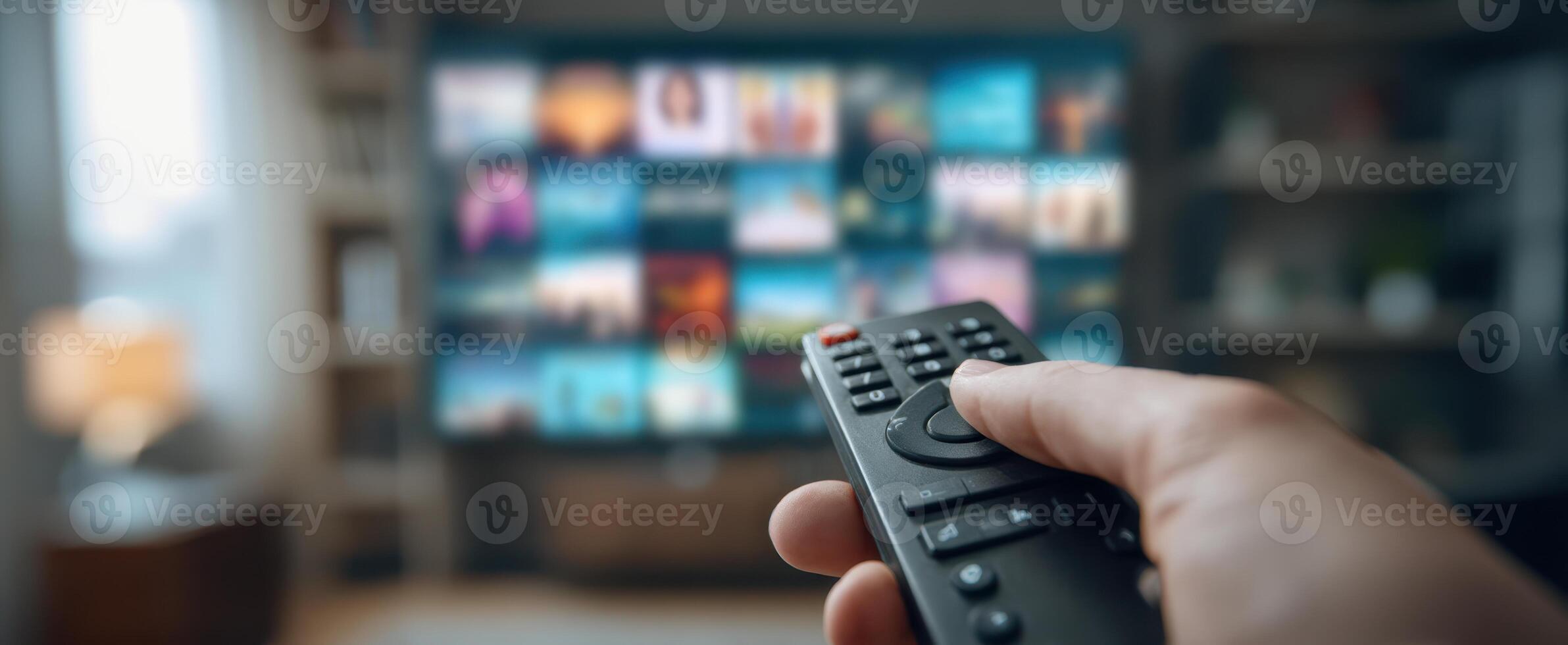 The remote control in hand ready to select a show on the television screen. photo