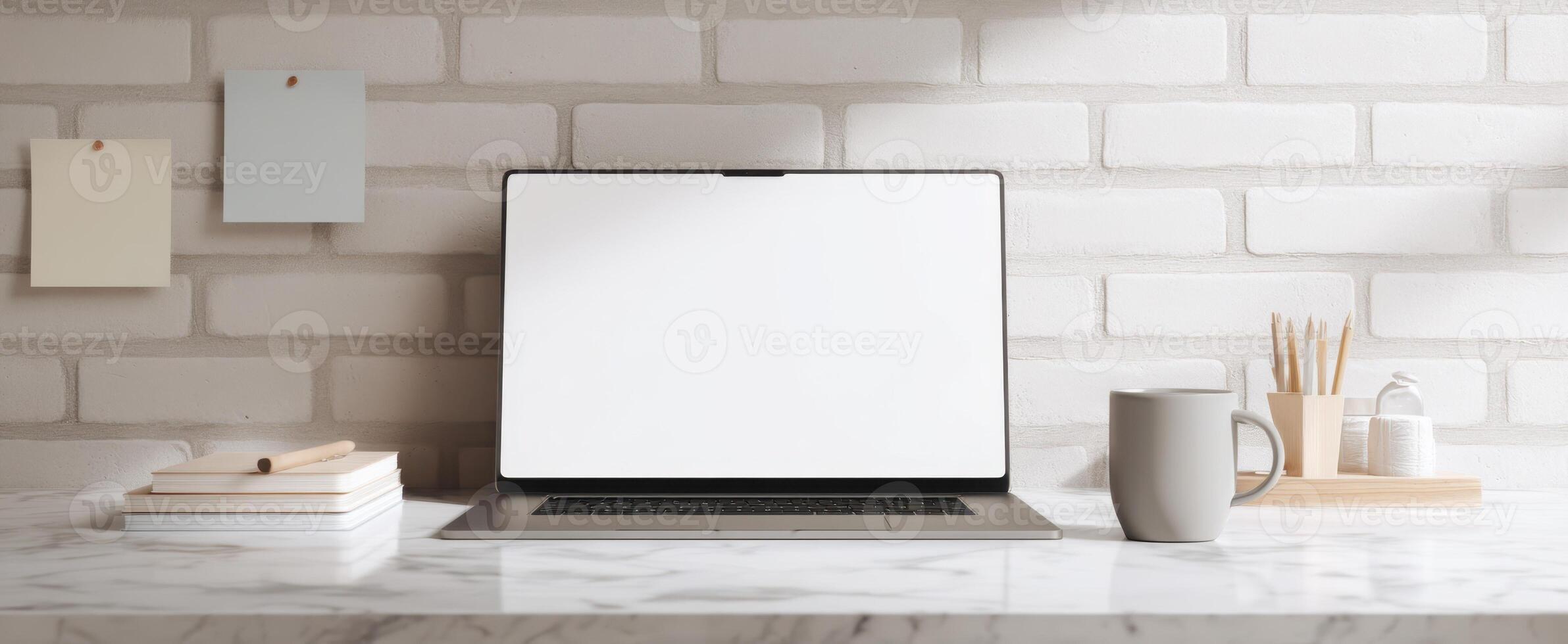 The sleek laptop and minimalist workspace with coffee and stationery on the desk. photo