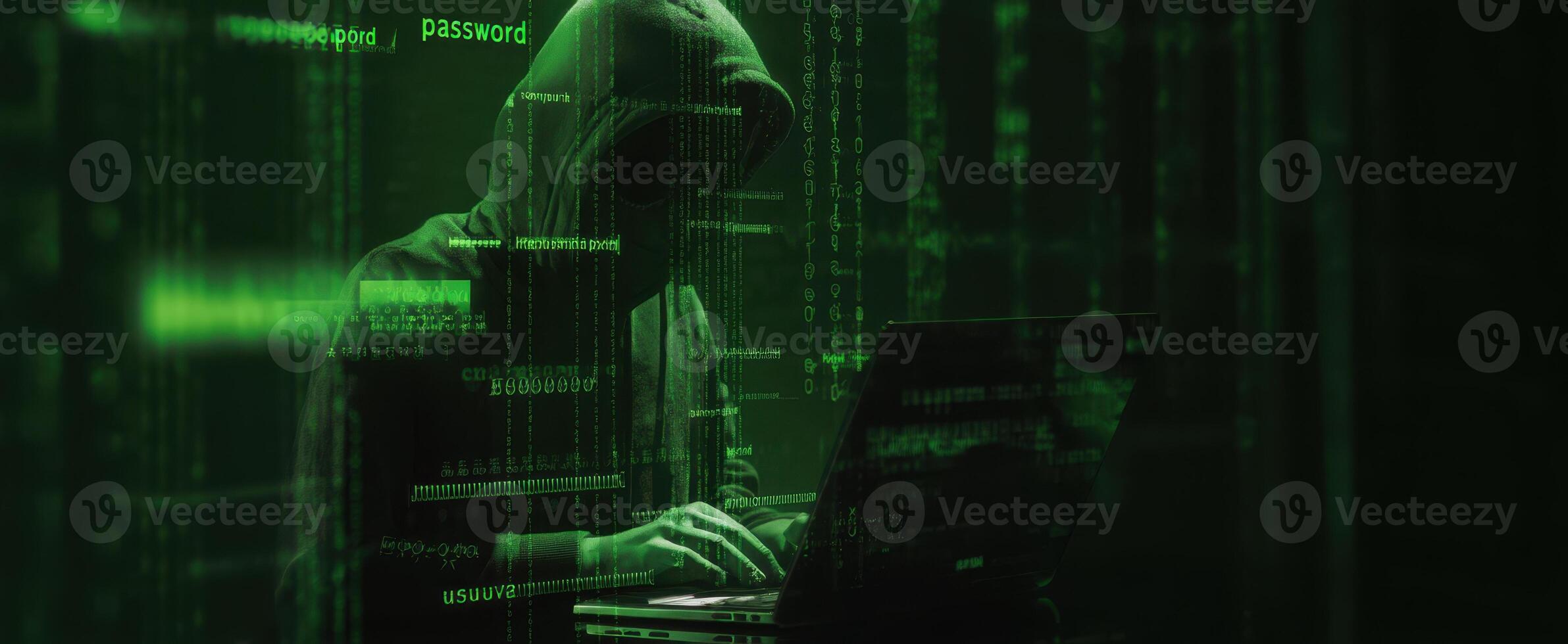 The hacker working intently on a laptop in a dark, green-lit environment. photo