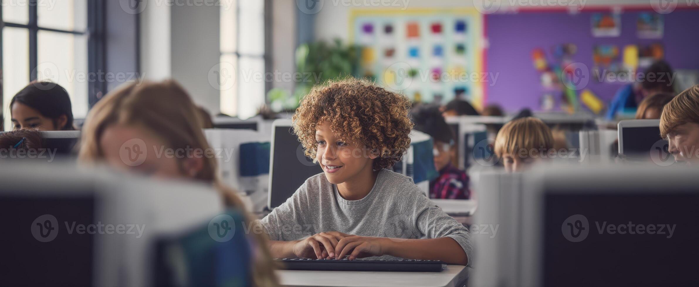The joyful child engaging with technology in a modern classroom setting. photo