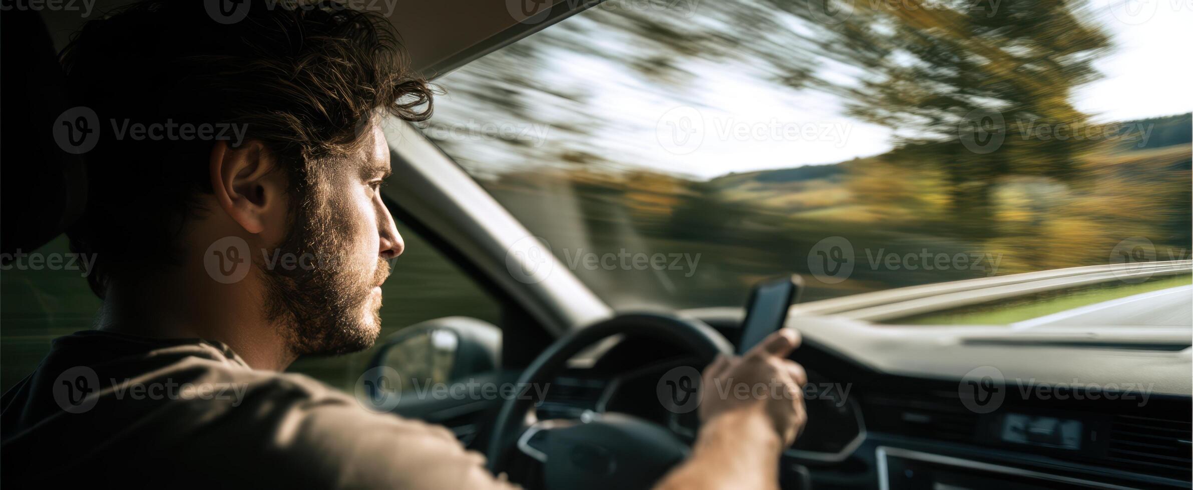 The man using a smartphone while driving on a scenic highway. photo