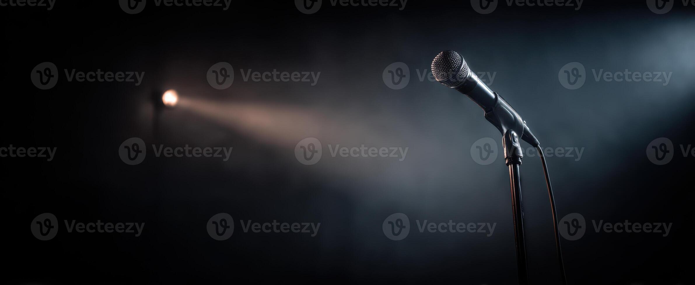 The microphone ready for performance under a dramatic spotlight on stage. photo