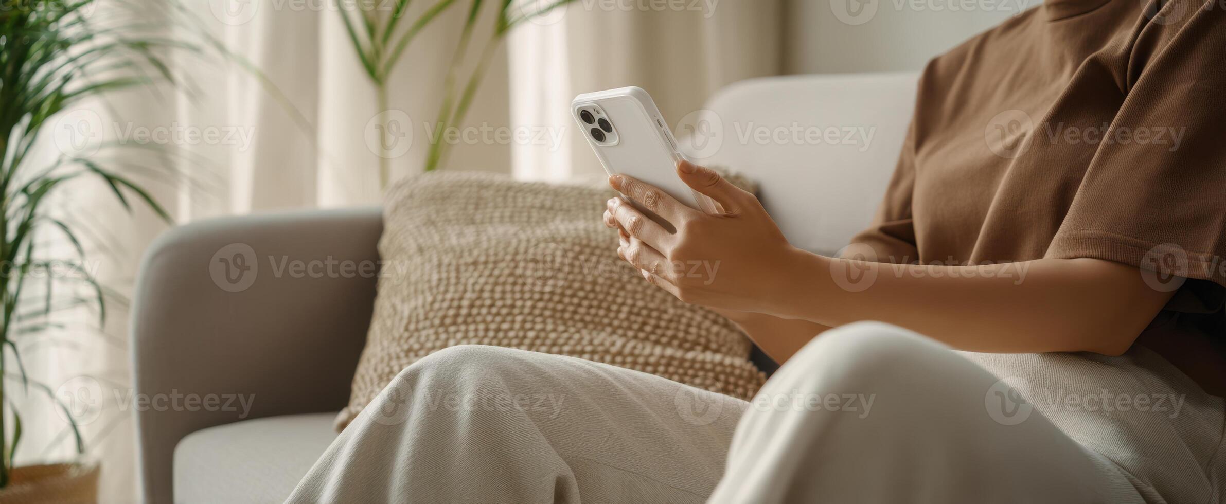 The person using a smartphone while sitting comfortably on a couch photo