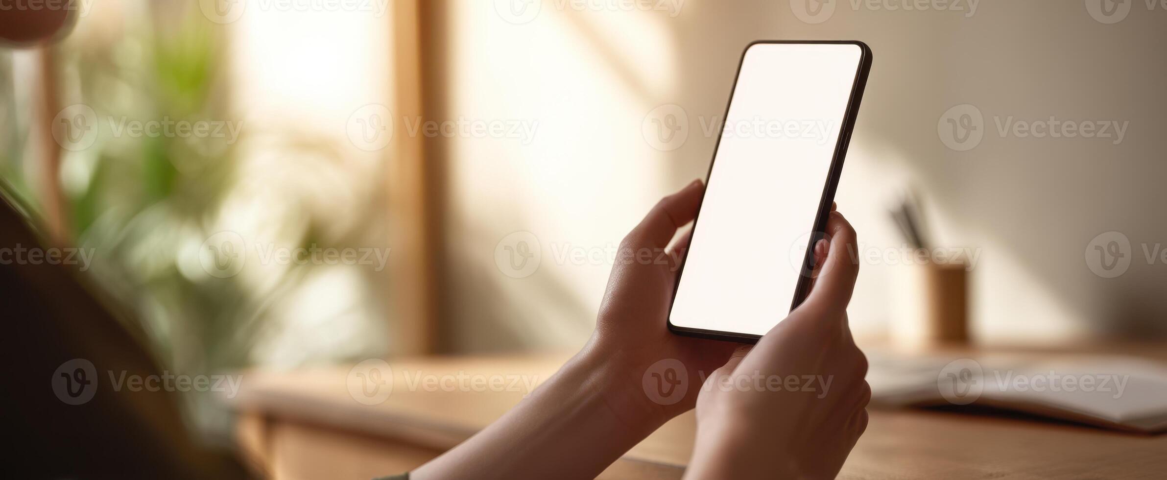 The smartphone held by a person in a serene home workspace setting. photo