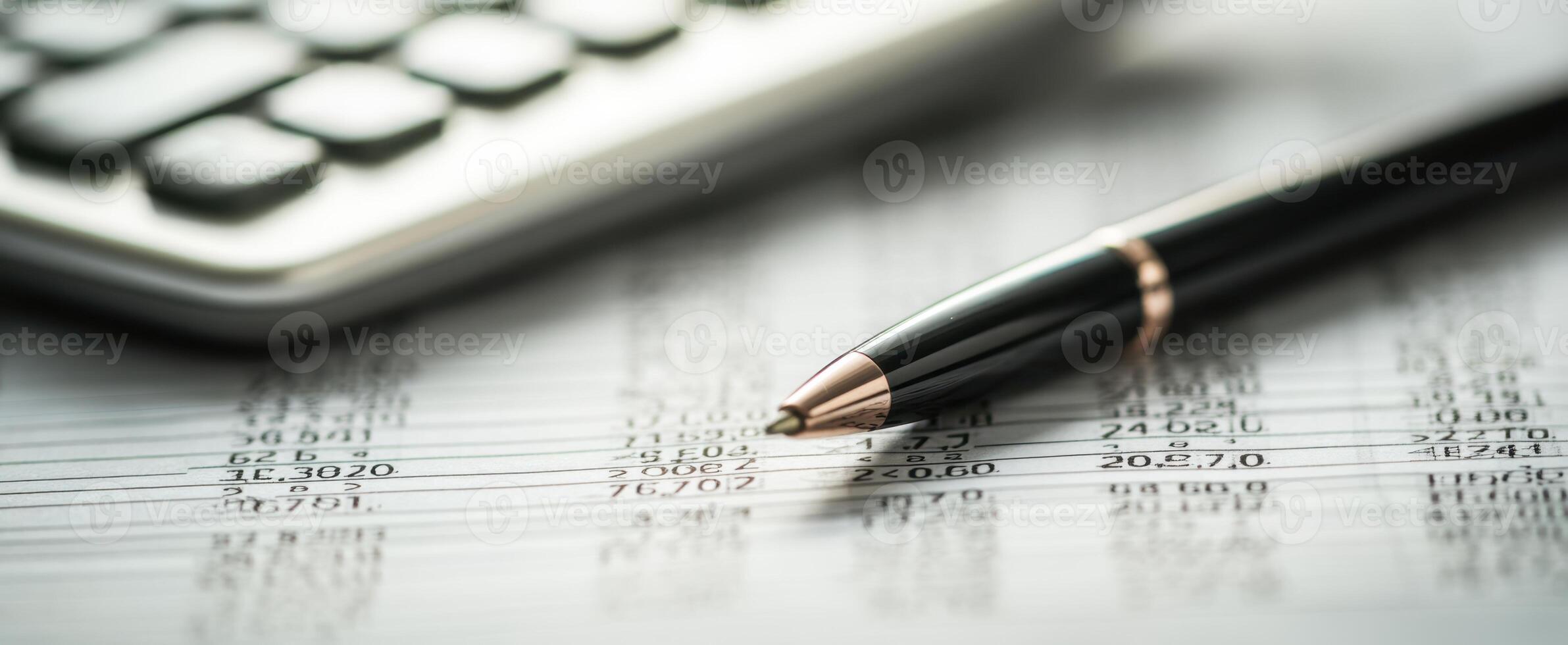 The elegant pen rests on a financial spreadsheet with calculator nearby. photo