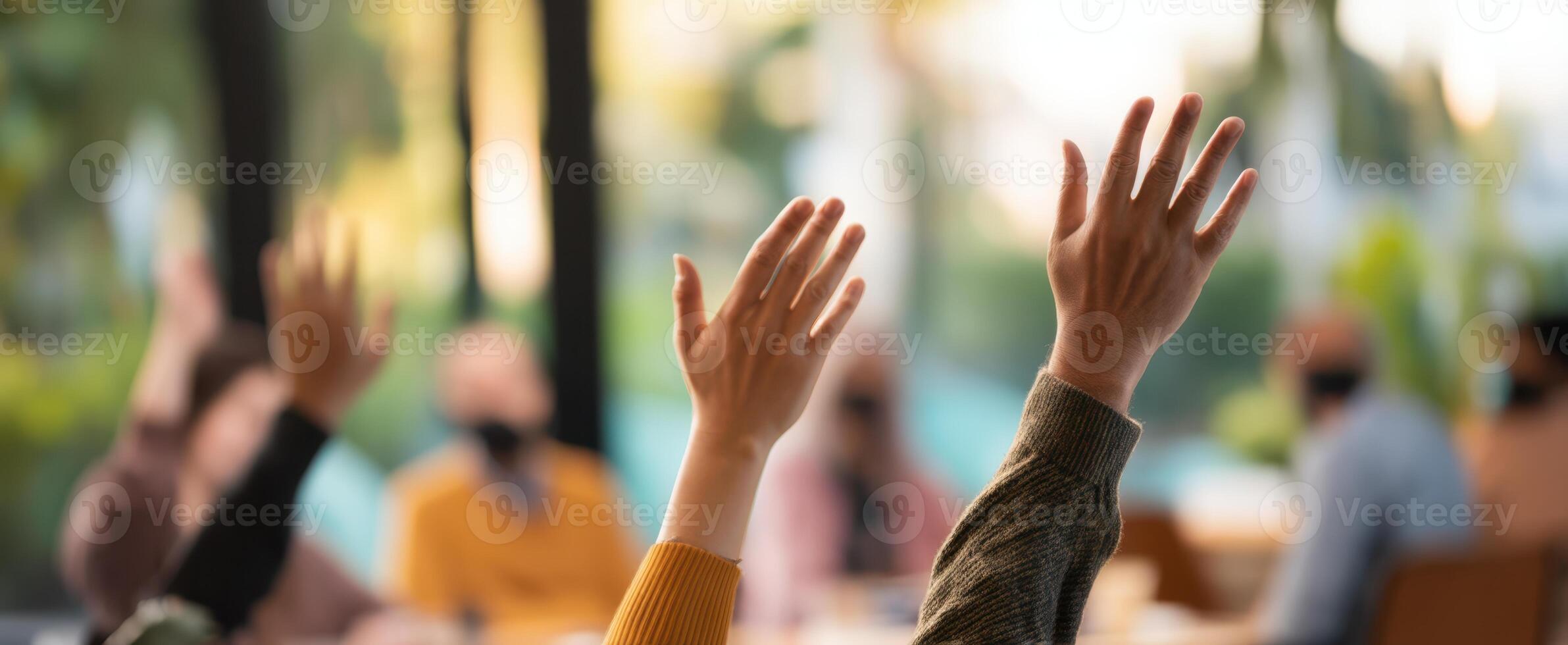 The engaged audience raising hands during an interactive group discussion session. photo