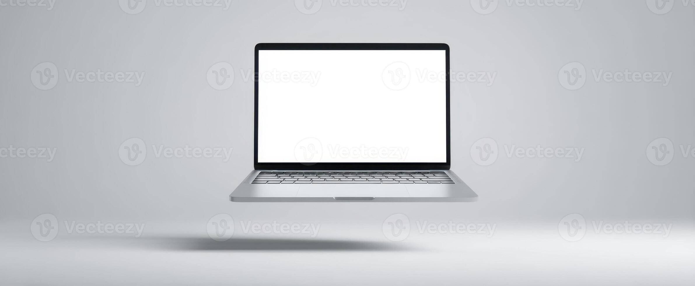 The floating laptop with a blank screen against a minimalist background. photo