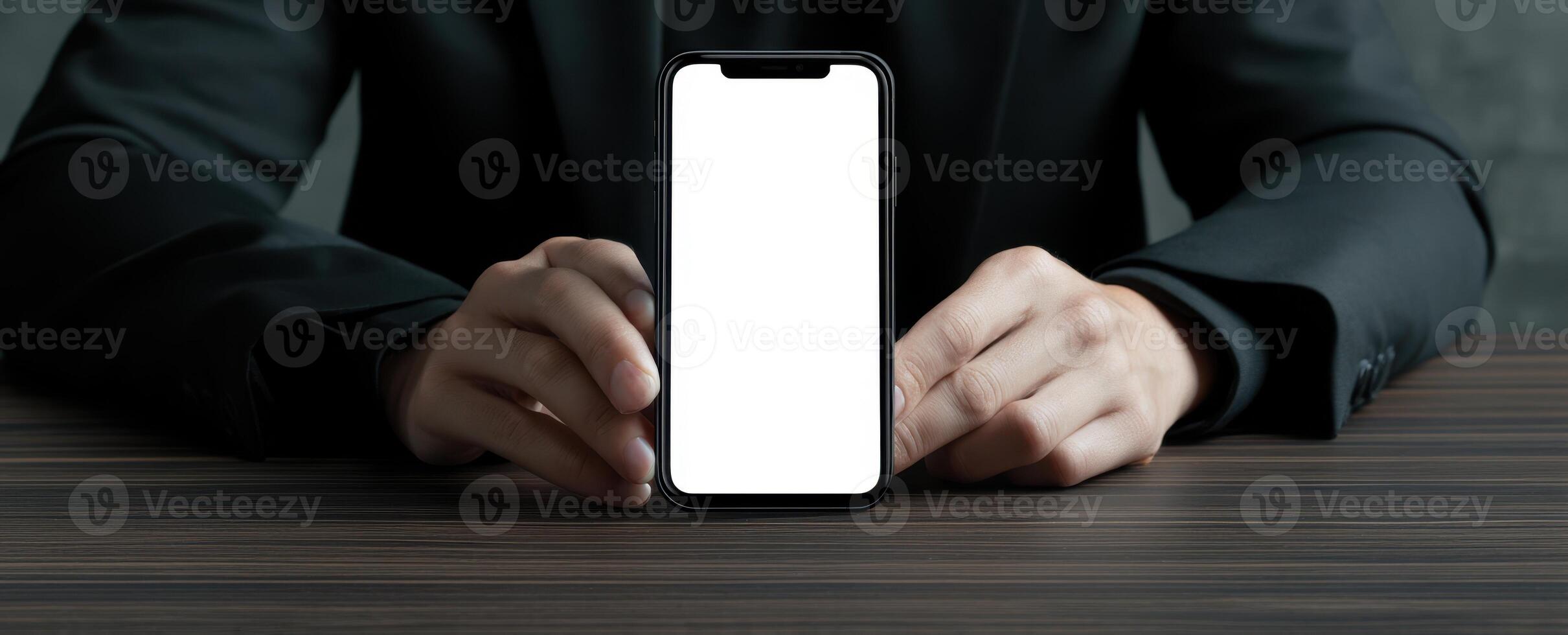 The smartphone held by a businessman on a wooden table background. photo