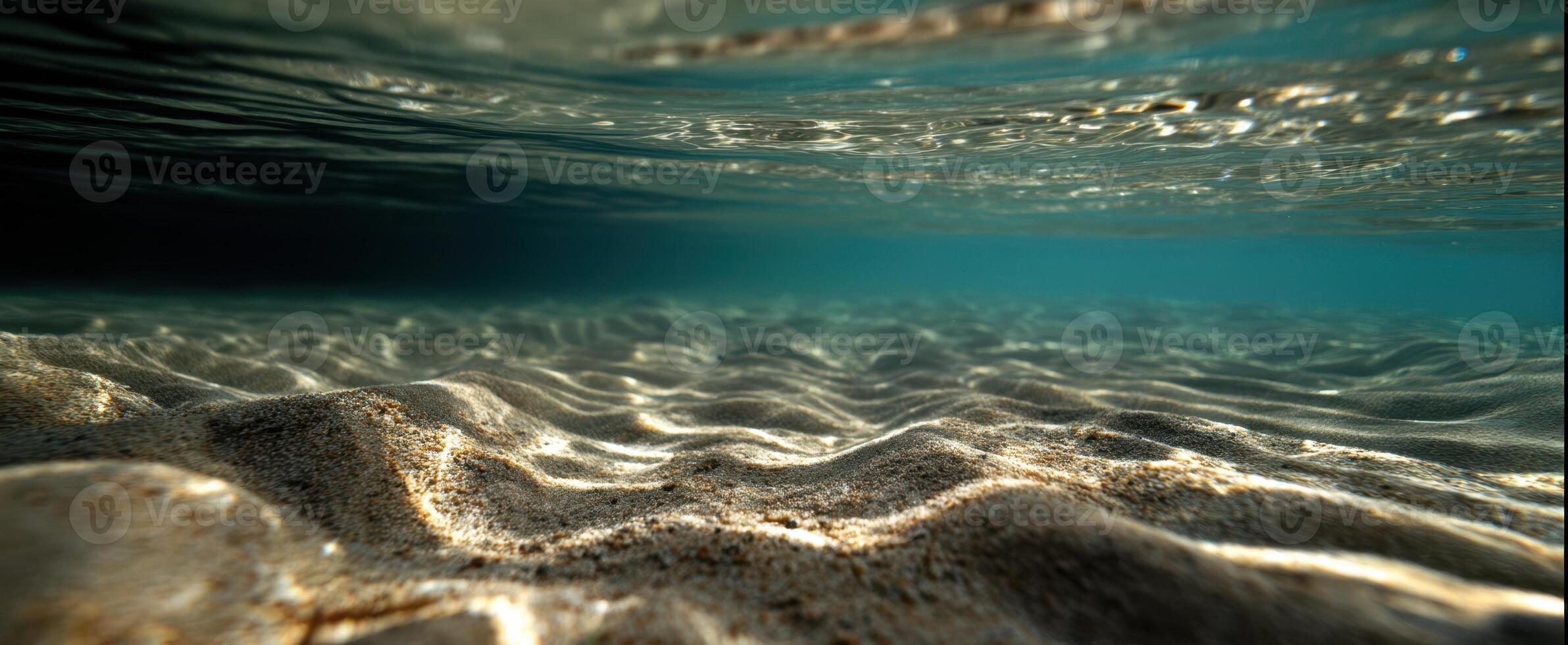 The tranquil underwater scene revealing sandy textures and gentle light. photo