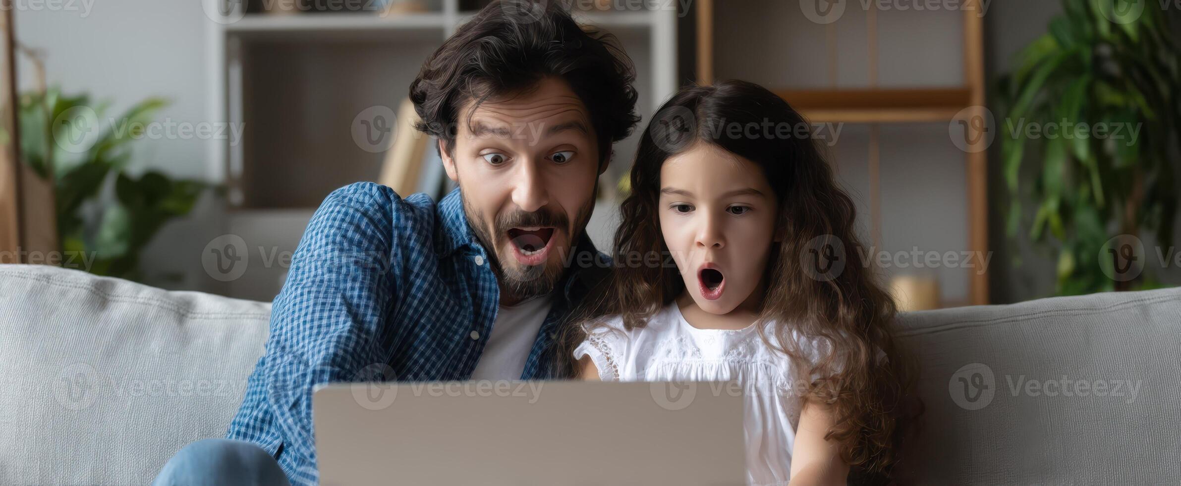 The father and daughter share a moment of surprise while using a laptop. photo