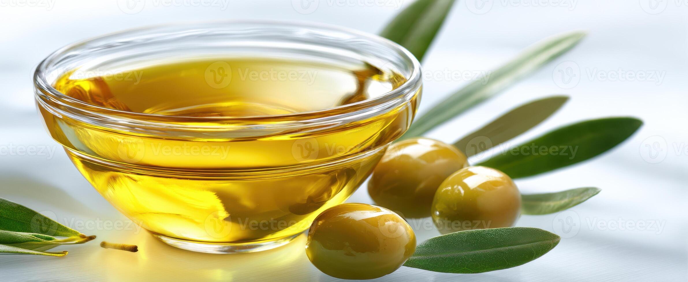 The bowl of olive oil with fresh olives and leaves on a light background. photo