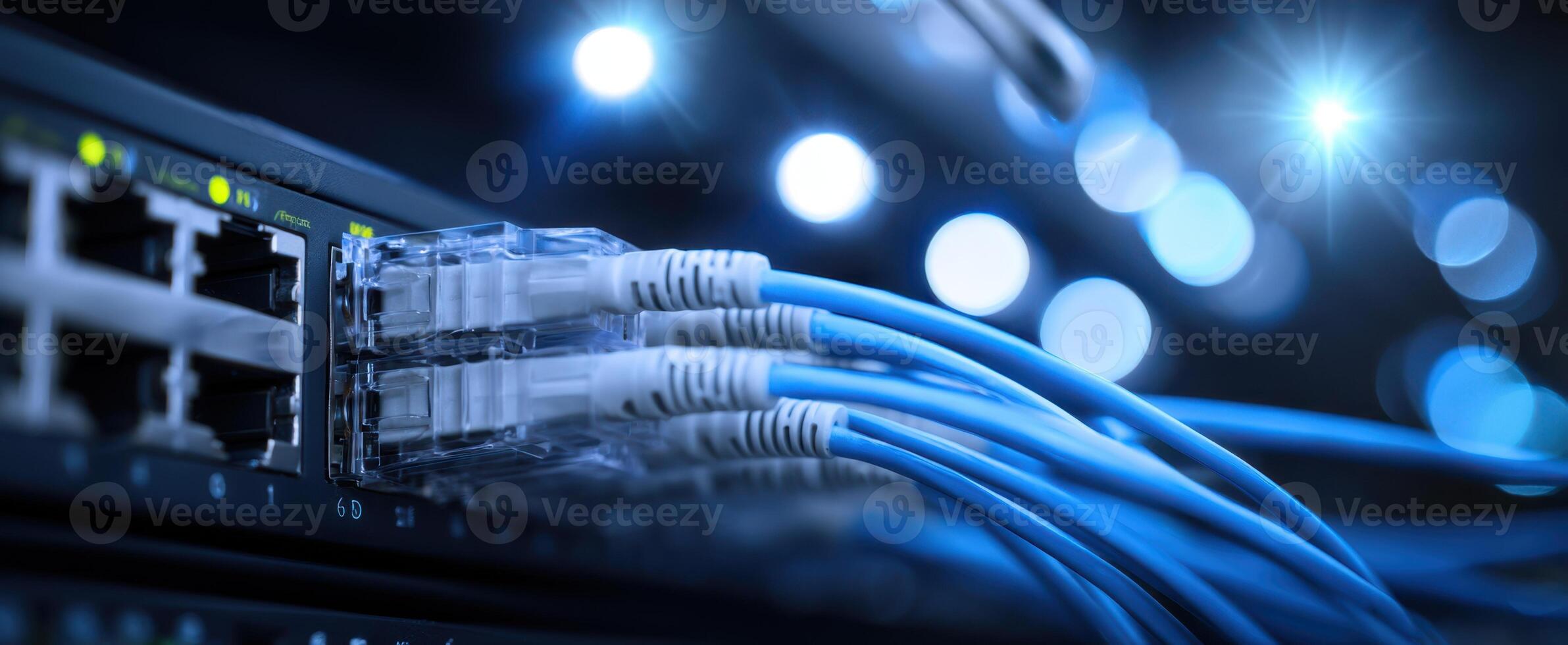 The Ethernet cables connecting to a network switch with blue lighting effects. photo