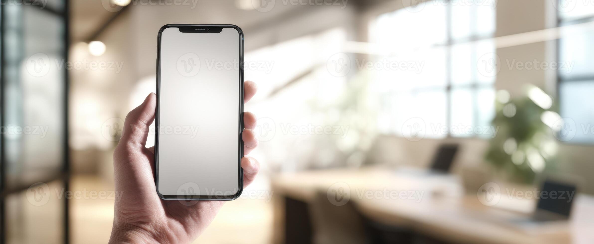 The smartphone held in a hand against a contemporary office background. photo