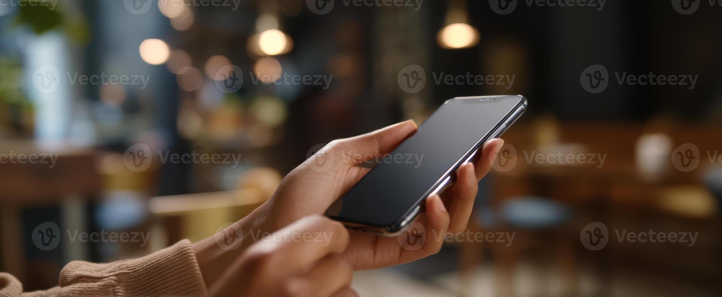 The smartphone in a hand, showcasing modern communication in a cozy cafe setting. photo